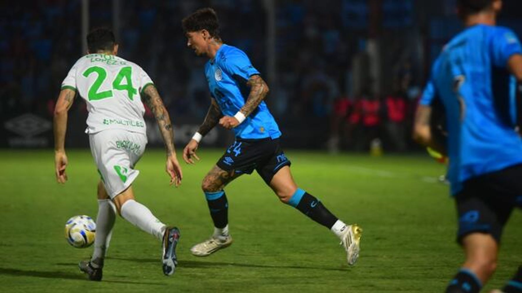Emiliano Rigoni intenta generar peligro para Belgrano, ante la cerrada defensa de Banfield.