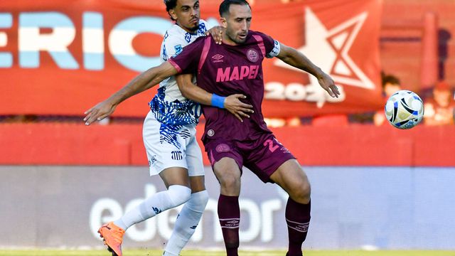 Ronaldo Martínez, el goleador que necesita Talleres, apura al "Cali" Izquierdoz en el partido con Lanús.