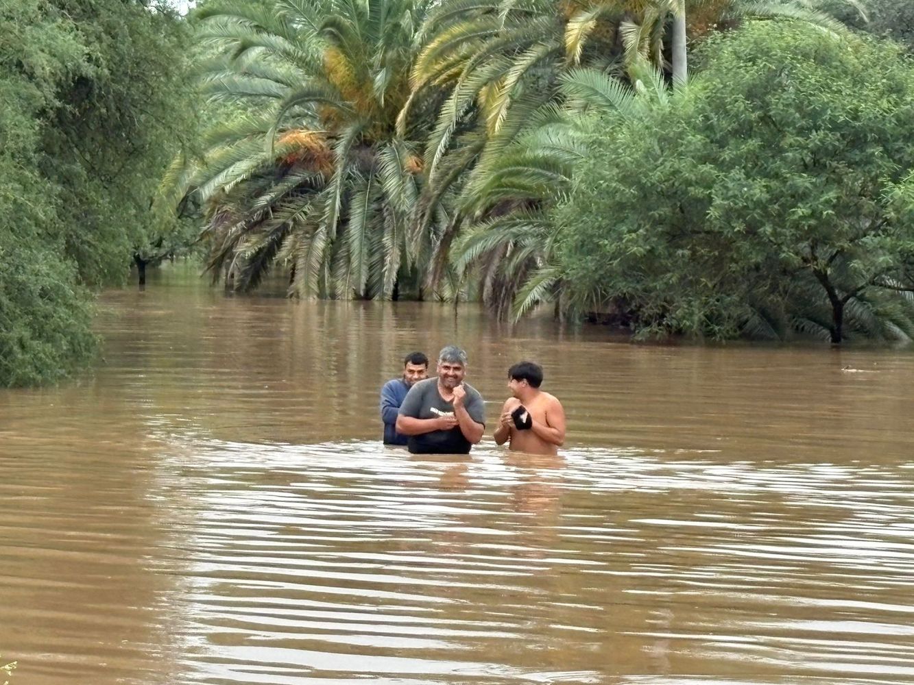 Vecinos dejando sus hogares con el agua al pecho.