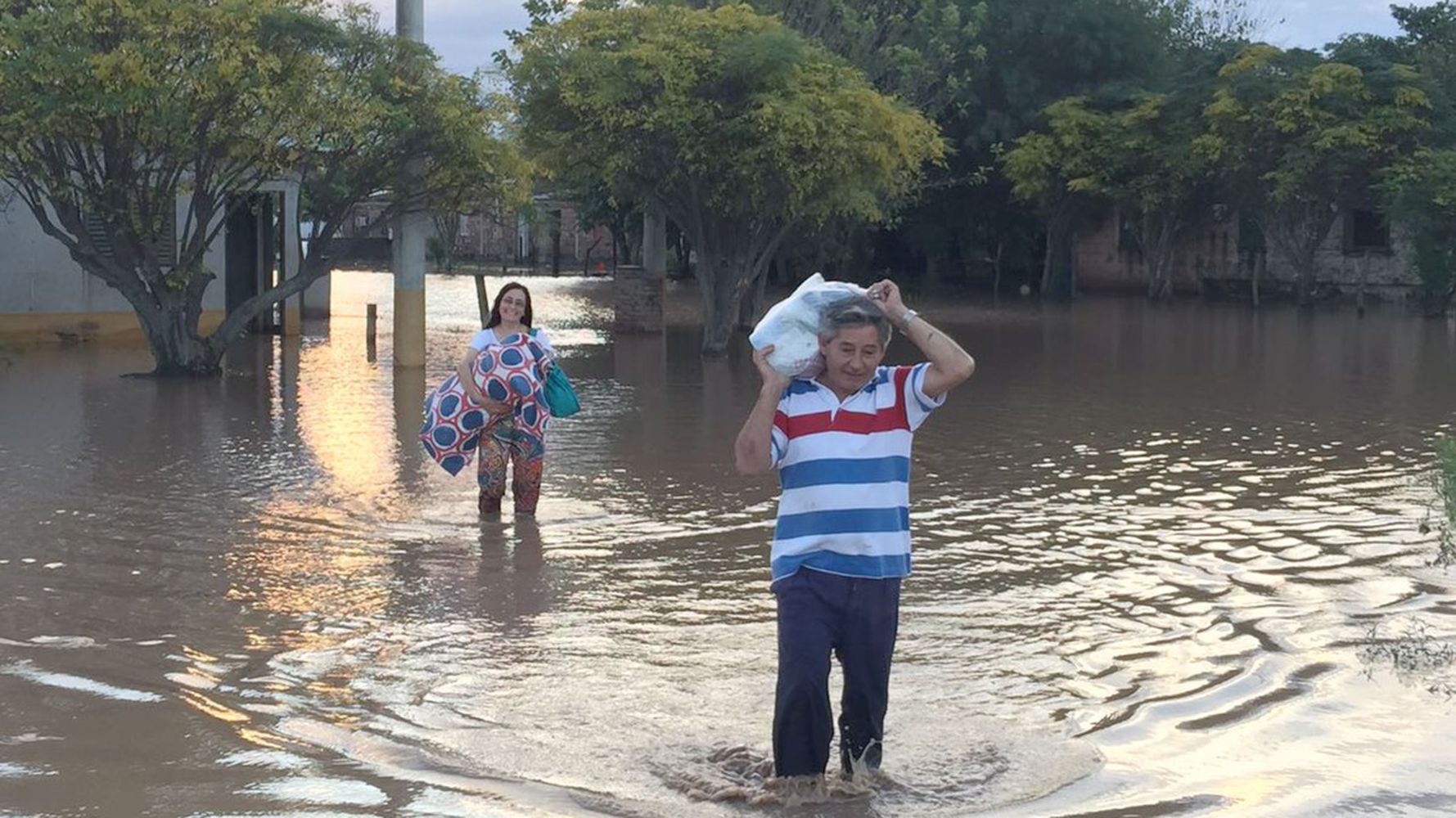 Vecinos y vecinas tratando de salvar algunas pertenencias.