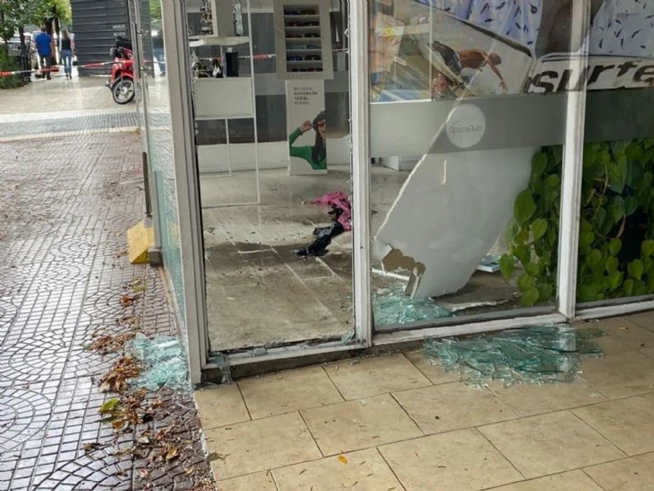Así quedó la vidriera de la óptica tras el impacto: vidrios rotos y daños en el ingreso al local.