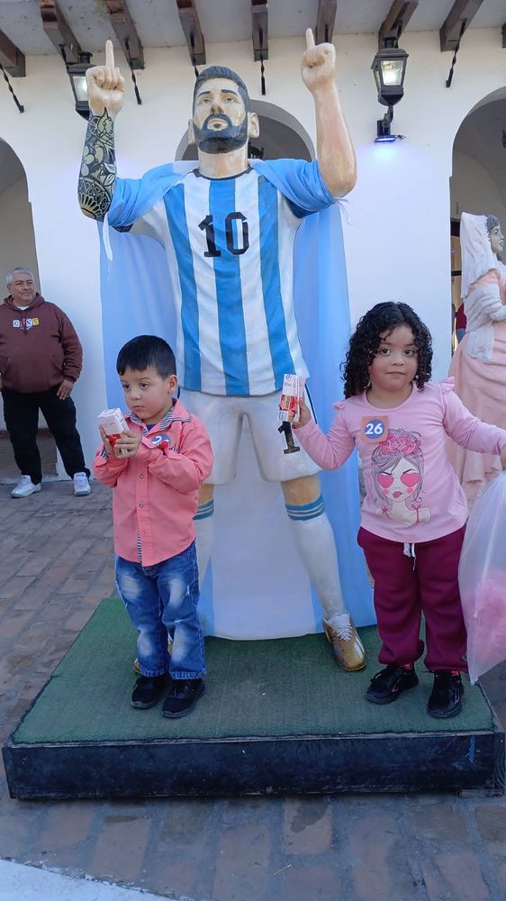 Niños junto a la estatua de Messi