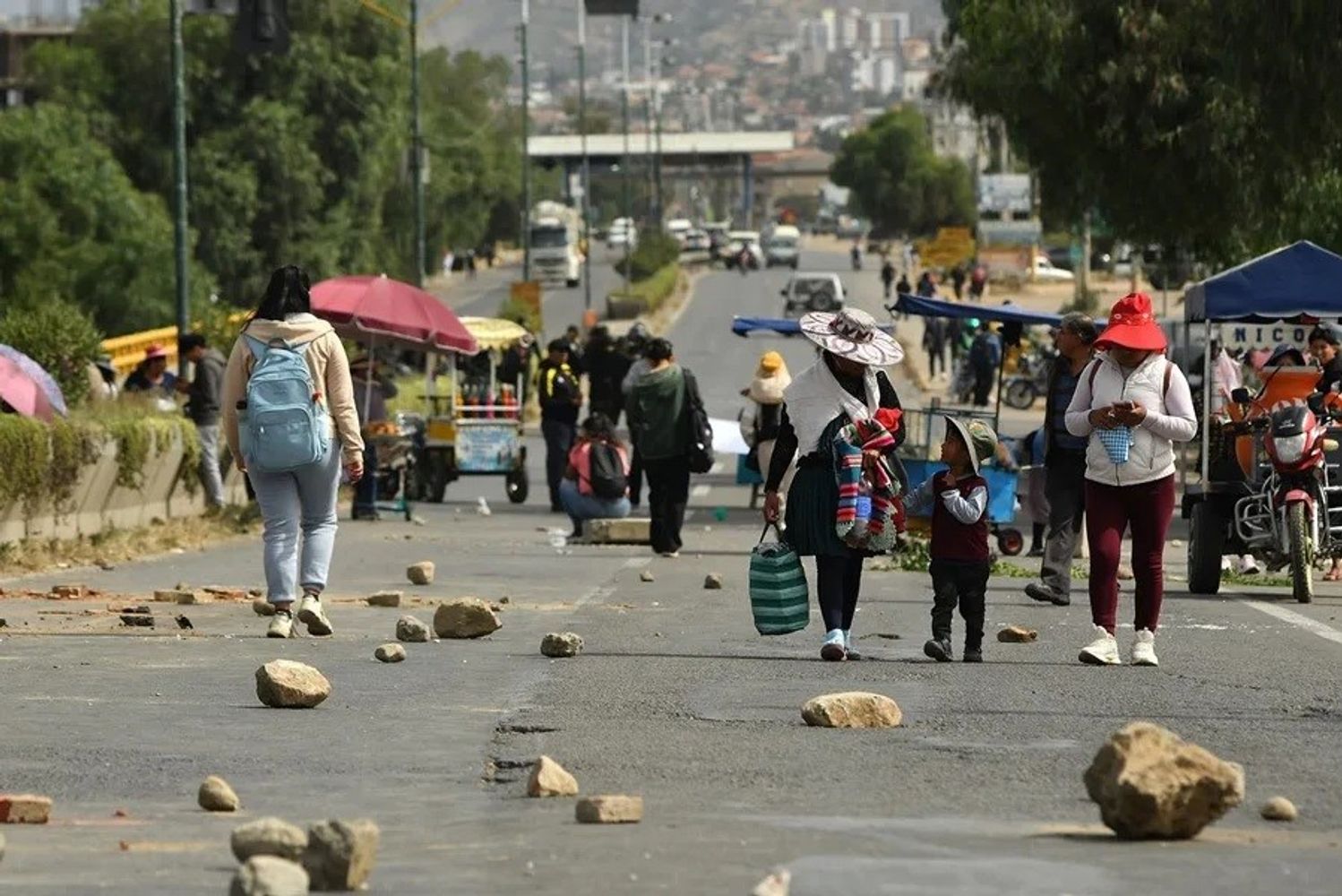 La imagen muestra personas caminando en una carretera bloqueada en Cochabamba, durante las jornadas de protestas del mes de junio. La Fiscalía boliviana investiga al expresidente Evo Morales por los presuntos delitos de "alzamientos armados y terrorismo".