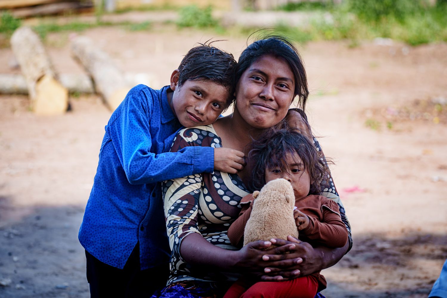 Lisa sonríe junto a su hija y su sobrino en la comunidad Tierra Indígena de Ballivián, Salta.