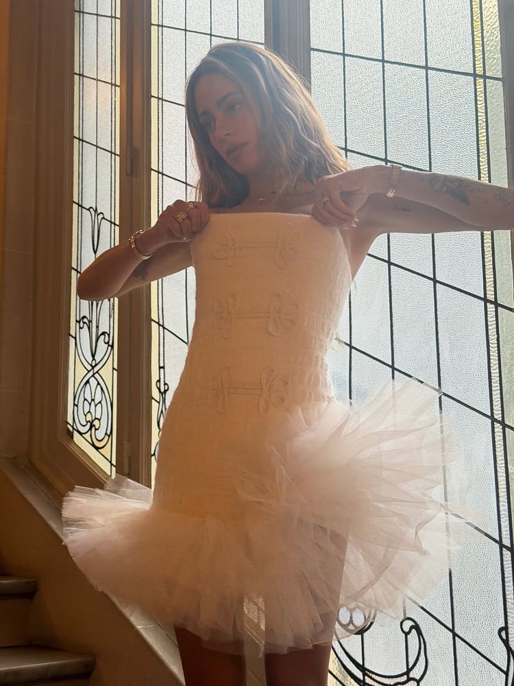 Minivestido "strapless" de punto con volado de tul y chaqueta sastrera: el look "balletcore" de Tini Stoessel