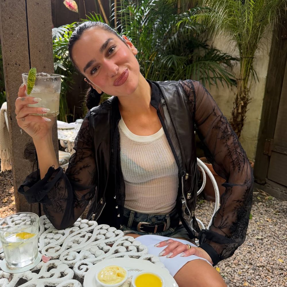 Campera de cuero con mangas de encaje, top translúcido y shorts de jean: el estilo urbano de Dua Lipa