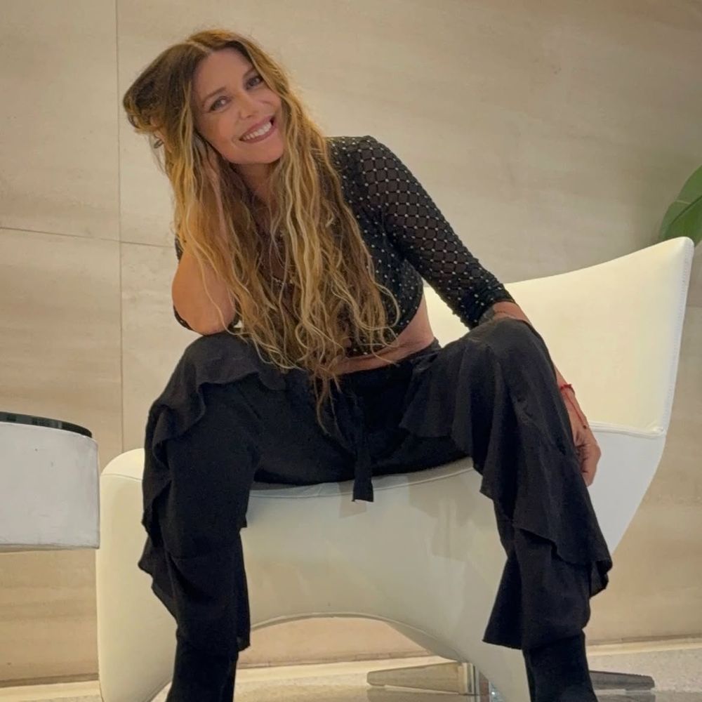 Top calado con brillos, pantalón con volados laterales y estética "boho chic": el look nocturno de Mónica Ayos a los 54 años