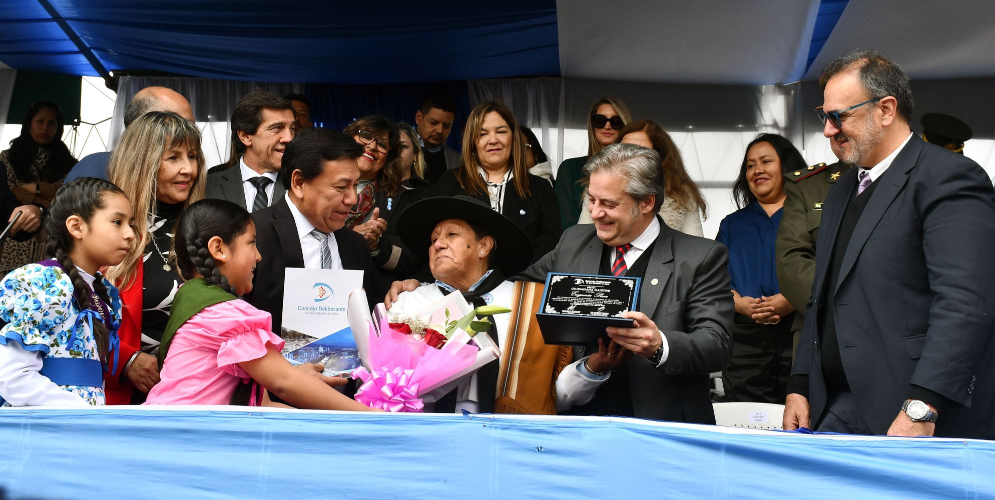 En el transcurso del desfile en Alto Comedero, concejales capitalinos entregaron a la referente Eugenia Puca una copia de su declaración como “ciudadana distinguida” por su extensa trayectoria como defensora de la tradición gauchesca e integrante de la Guardia de Honor Gaucha de la capital jujeña.