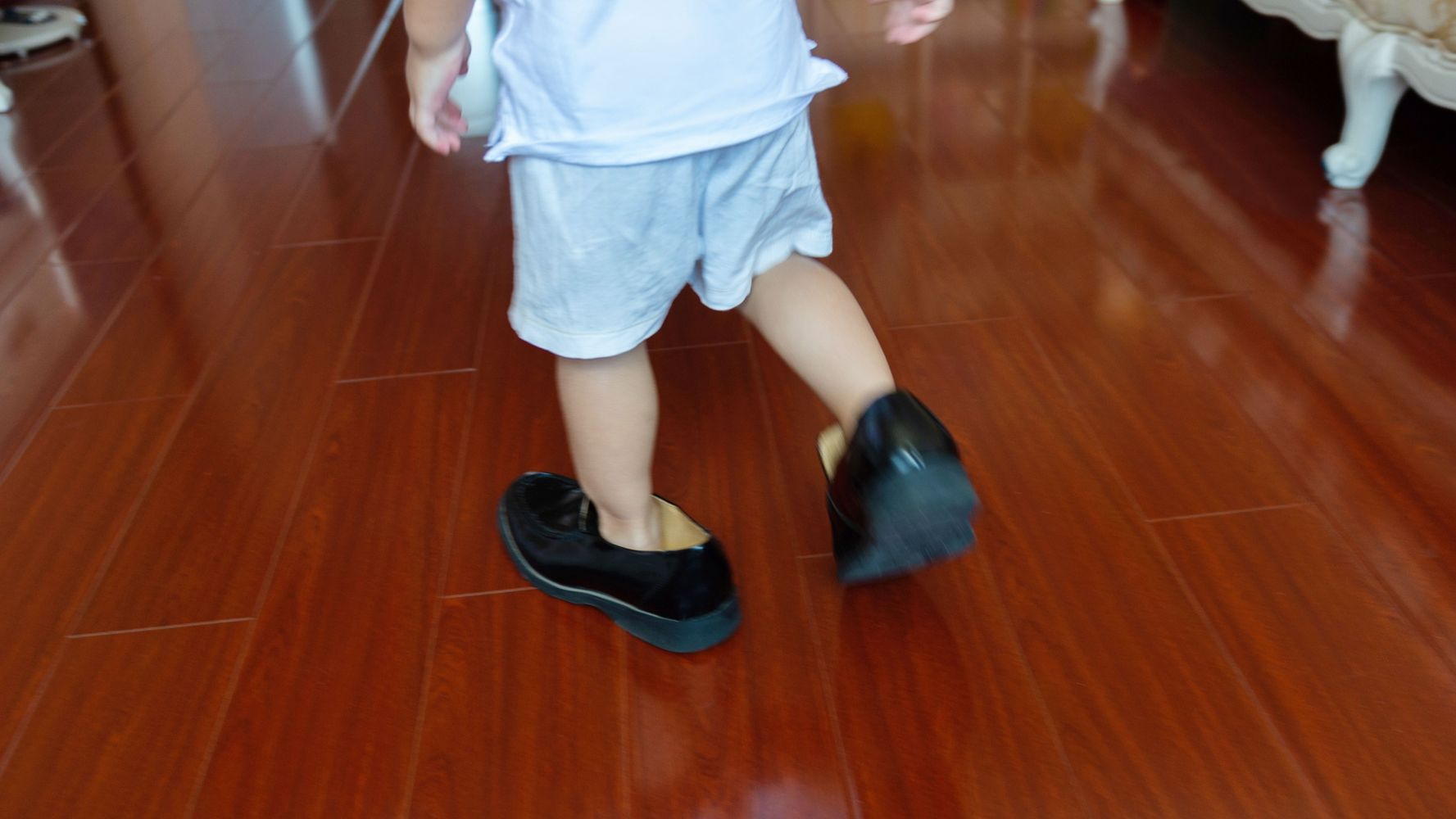 Niño se prubea los zapatos de su papá.