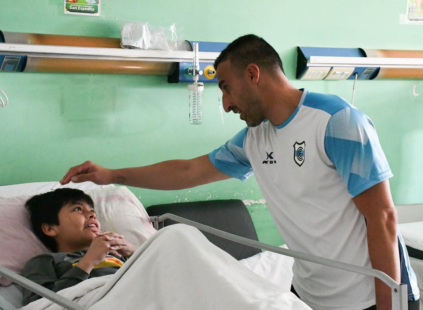 El director técnico Hernán Pellerano, en tierno diálogo con un simpático "hincha" del "Lobo", durante la visita al Hospital Materno Infantil “Dr. Héctor Quintana” de esta capital.