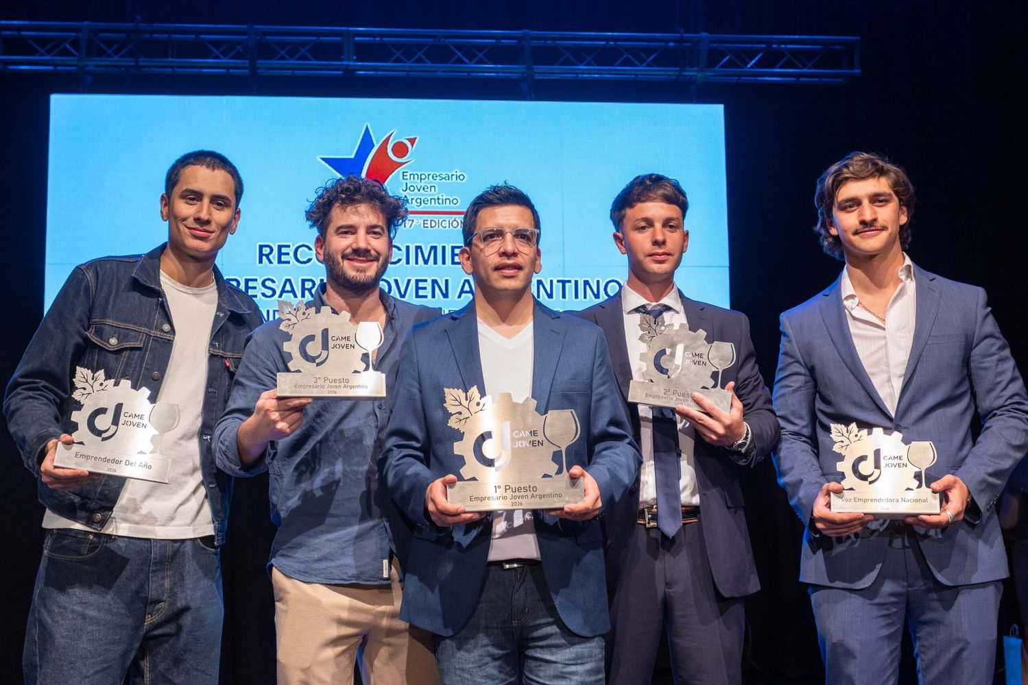 El jujeño Ezequiel Escobar sostiene el trofeo del premio “Joven Empresario Argentino 2026”, que le fue otorgado por la CAME. El segundo puesto fue para el mendocino Gregorio Bajda y el tercer lugar para Jonatan Manuel Tournour, de la provincia de Entre Ríos.