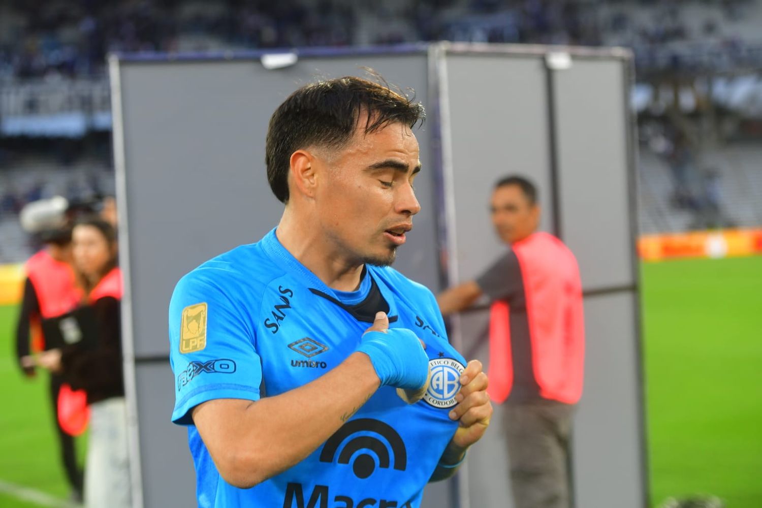 El Chino Zelarayán se muestra el escudo tras la victoria de Belgrano ante Talleres.