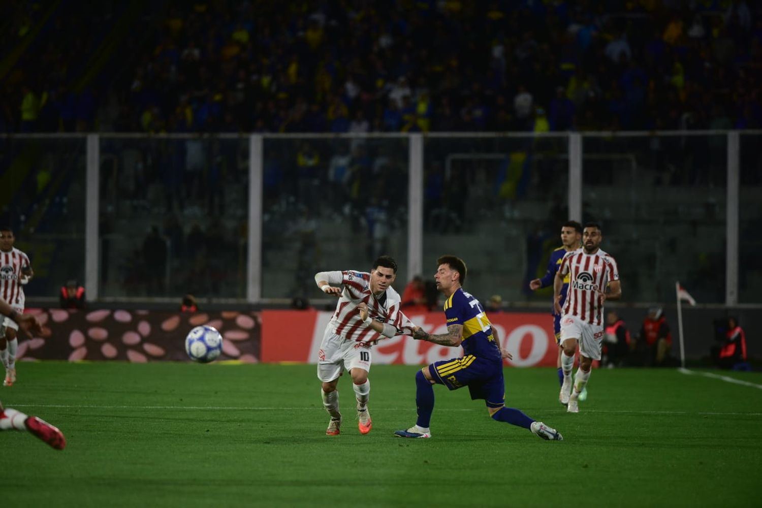 Alex Luna se la lleva ante el ex Instituto, Malcon Braida. La Gloria ante Boca en el Kempes.