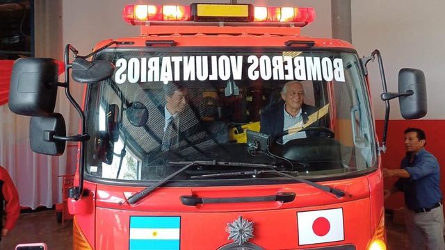 El embajador de Japón en la República Argentina, Hoshino Yoshitaka, y a su lado, al volante de la autobomba, el intendente de Perico, Rolando Pascual Ficoseco.