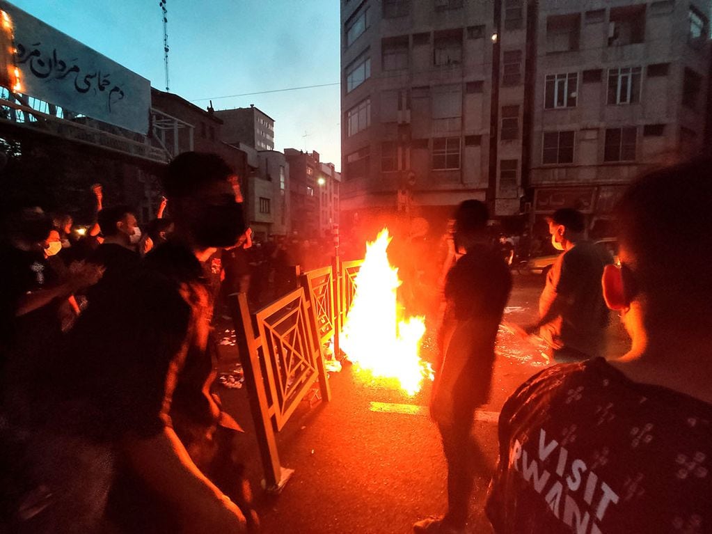 Manifestantes encienden fuego y bloquean la calle durante una protesta en el centro de Teherán. Foto: AP.