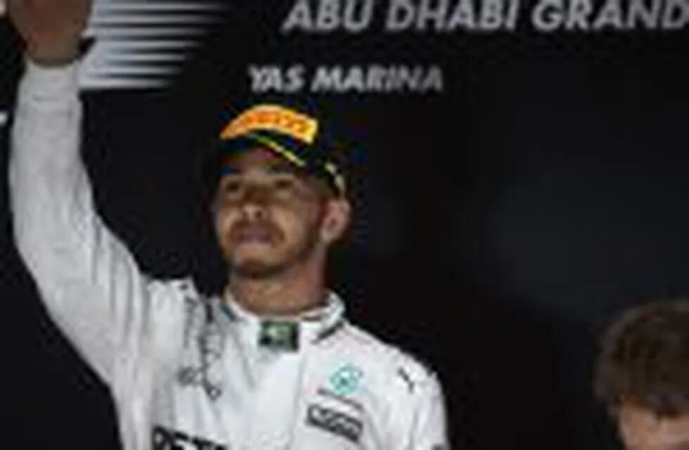 Mercedes AMG Petronas F1 Team's British driver Lewis Hamilton celebrates after winning the Abu Dhabi Formula One Grand Prix at the Yas Marina circuit on November 27, 2016.nNico Rosberg won his maiden Formula One world title by securing second place behind his Mercedes arch-rival Lewis Hamilton in the Abu Dhabi Grand Prix. / AFP PHOTO / MOHAMMED AL-SHAIKH