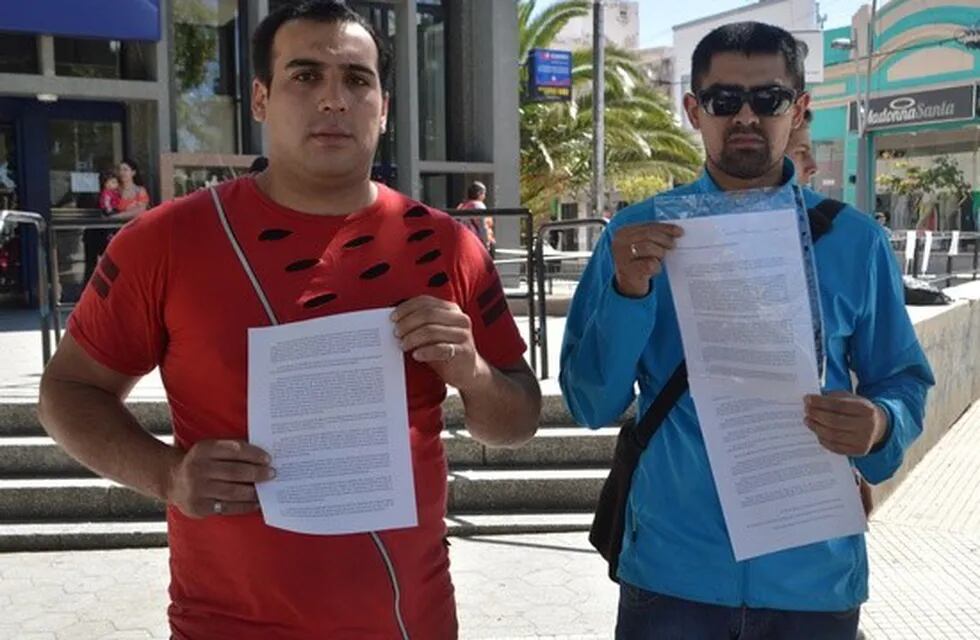 Dos jóvenes juntan firmas para pedirle trabajo a Alberto Rodríguez Saá.