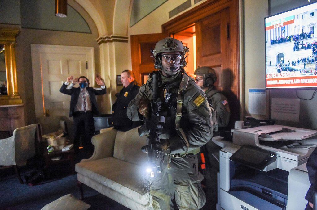 Un congresista levanta sus brazos mientras el equipo Swat del Capitolio revisa una habitación