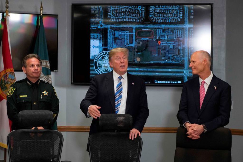 US President Donald Trump (C) speaks with Broward County Sheriff Scott Israel (L) and Florida Governor Rick Scott (R) while visiting first responders at Broward County Sheriff's Office in Pompano Beach, Florida, on February 16, 2018.
US President Donald Trump and First Lady Melania Trump visited a Florida hospital to offer their respects to the victims of a mass shooting that claimed 17 lives at a nearby high school.

 / AFP PHOTO / JIM WATSON