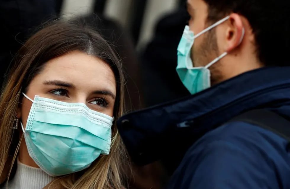A couple wear face masks to protect against the Coronavirus outbreak as they visit Buckingham Palace in London, Saturday, March 14, 2020. For most people, the new coronavirus causes only mild or moderate symptoms, such as fever and cough. For some, especially older adults and people with existing health problems, it can cause more severe illness, including pneumonia. (AP Photo/Frank Augstein)