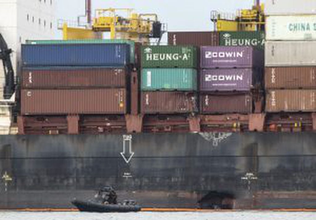 WAL08 SINGAPUR 04/01/2017.- Un barco del equipo de Respuesta de Vertido Marítimo permanece junto al barco gibraltareño APL Denver en el puerto de Pasir Gudang en Malasia, visto desde el mar cerca de la costa de Singapur hoy, 4 de enero de 2017. La colisió