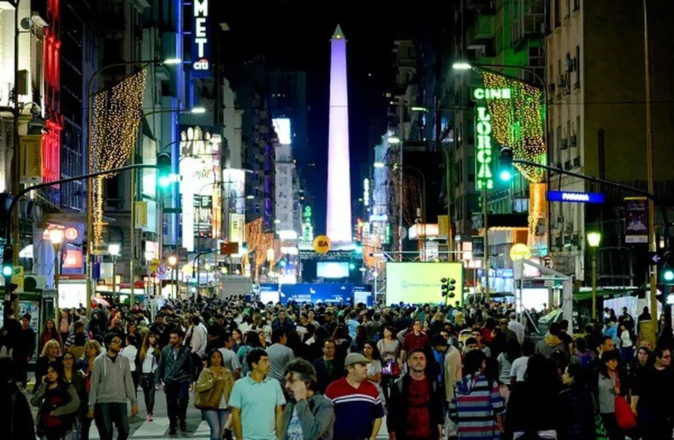 La calle Corrientes en el microcentro porteño repleta de gente consumiendo en bares, restaurantes, cines y teatros.