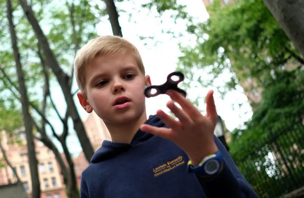Ten-year-old Louis Wuestenberg plays with a fidget spinner in a park in New York on May 23, 2017. nIt was supposed to calm nerves, relieve stress and improve concentration but the new-anti fidget toy spreading fast through US and European schools is whipping up anger among teachers on both sides of the Atlantic. Just months after the 