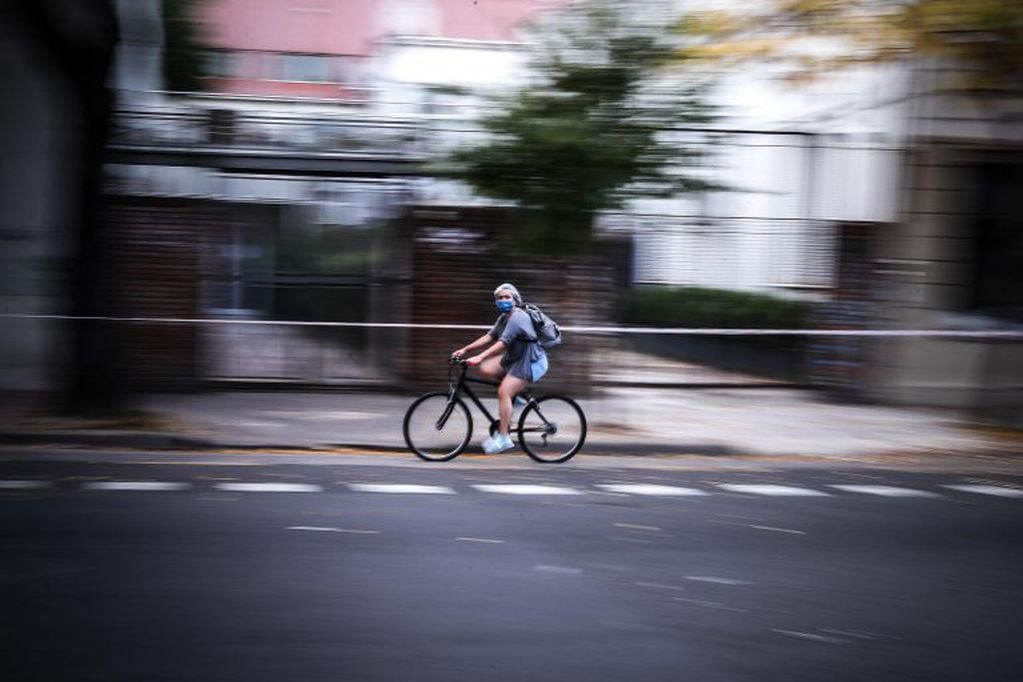 Una mujer con tapabocas transita en bicicleta este jueves en una jornada de la cuarentena obligatoria a causa de la COVID-19 en la Ciudad de Buenos Aires (EFE/Juan Ignacio Roncoroni)