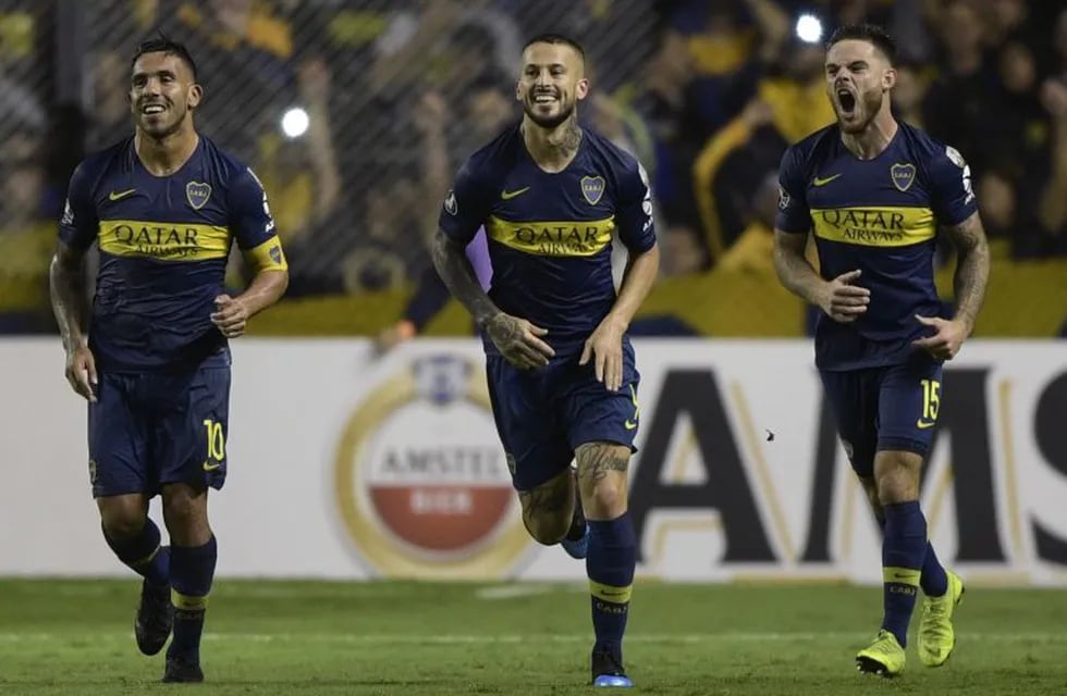 Argentina's Boca Juniors forward Dario Benedetto (C) celebrates next to teammates forward Carlos Tevez (L) and Uruguayan midfielder Nahitan Nandez after shooting a penalty kick to score his team's second goal, against Bolivia's Wilstermann during the Copa Libertadores 2019 group G football match at the \