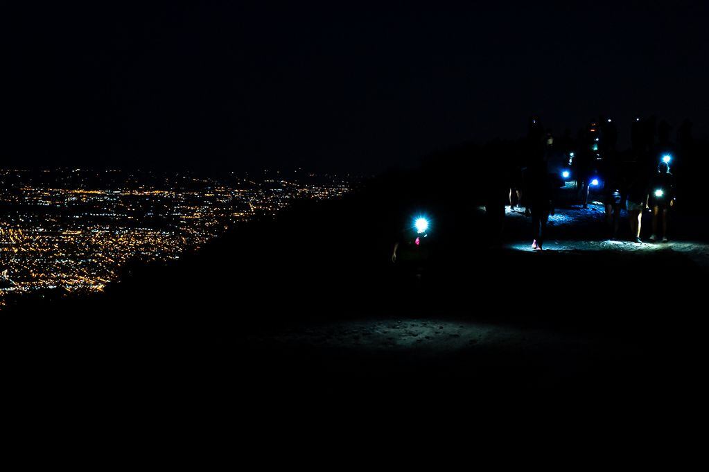 Caminata en la noche de El Challao con la imponente imagen de la ciudad.
