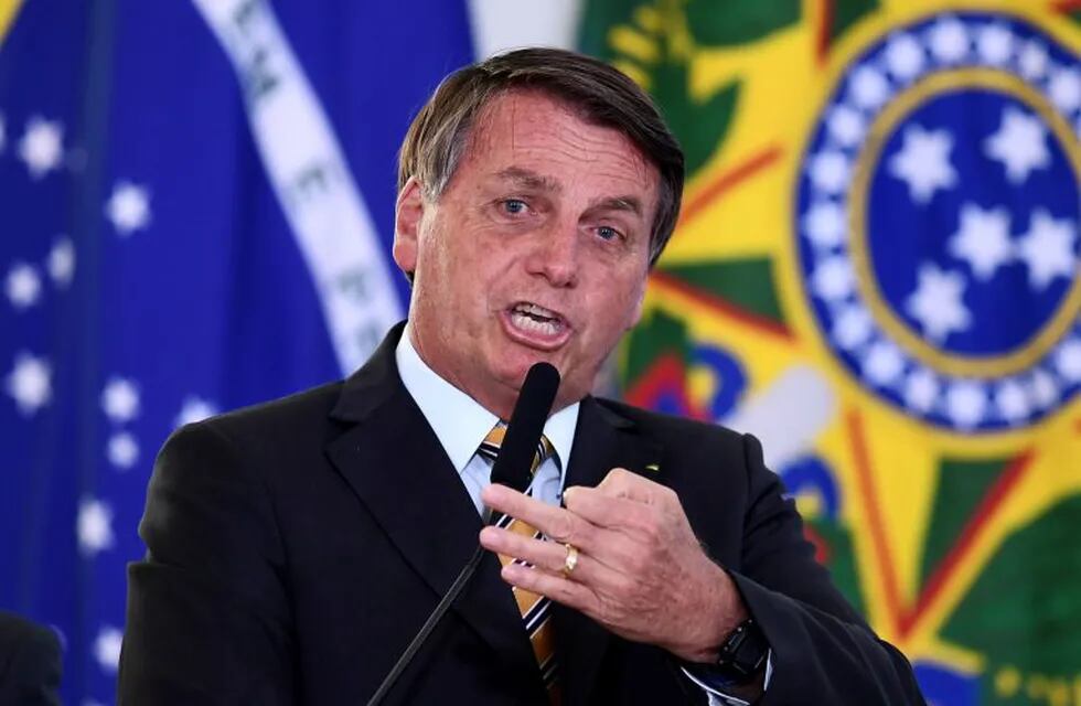 Brazilian President Jair Bolsonaro gestures as he speaks during the launch of a program for the resumption of tourism, a sector severely affected by the new coronavirus outbreak, at Planalto Palace in Brasilia, on November 10, 2020. - Brazil's decision to halt trials of a Chinese-developed Covid-19 vaccine triggered a politically charged row Tuesday as a top health official expressed \