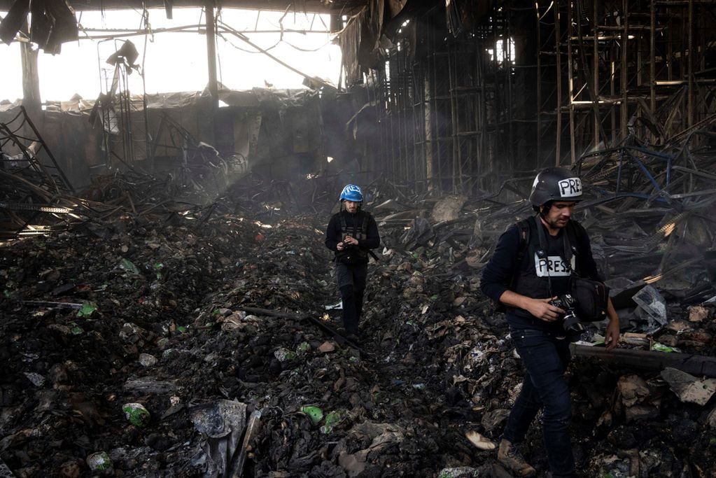 Periodistas caminan dentro de un almacén destruido después de un ataque de Rusia hace doce días en Brovary, en las afueras de Kiev.  (AP/Rodrigo Abd, File)
