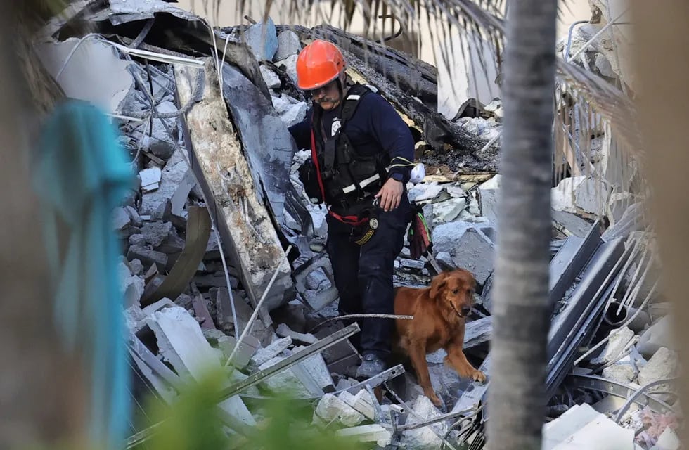 Bomberos y rescatistas buscan personas desaparecidas bajo los escombros, tras el derrumbe parcial de un edificio en Surfside, Miami.