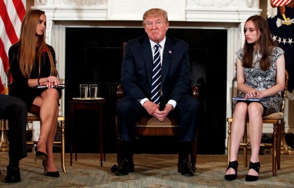President Donald Trump, joined by Marjory Stoneman Douglas High School student Carson Abt, right, and Julia Cordover, the student body president at the school, pauses during a listening session with high school students teachers and others in the State Dining Room of the White House in Washington, Wednesday, Feb. 21, 2018. (AP Photo/Carolyn Kaster)