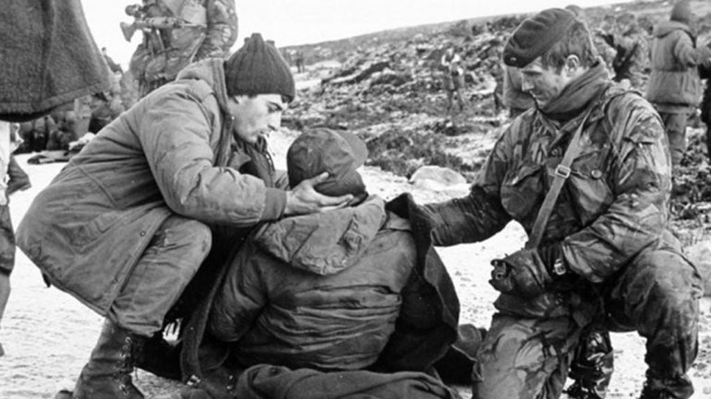 Códigos de guerra: Soldados Argentinos asistidos por un soldado británico despues del alto el fuego. Esta actitud demuestra caballerocidad entre los contendientes.