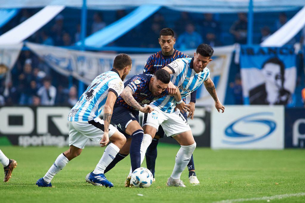 Nahuel Bustos, rodeado, en el partido que Talleres afrontó en Tucumán ante Atlético. (Prensa Talleres)