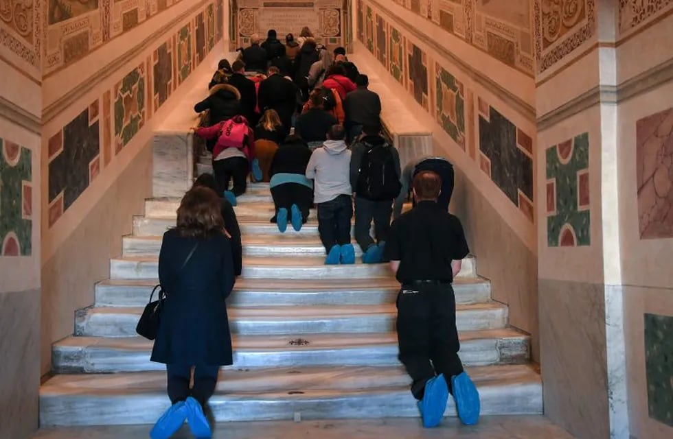 Faithfuls kneel on the new restored Holy Stair (Scala Santa) at San Giovanni in Laterano in Rome during a special opening on April 12, 2019. (Photo by Tiziana FABI / AFP)