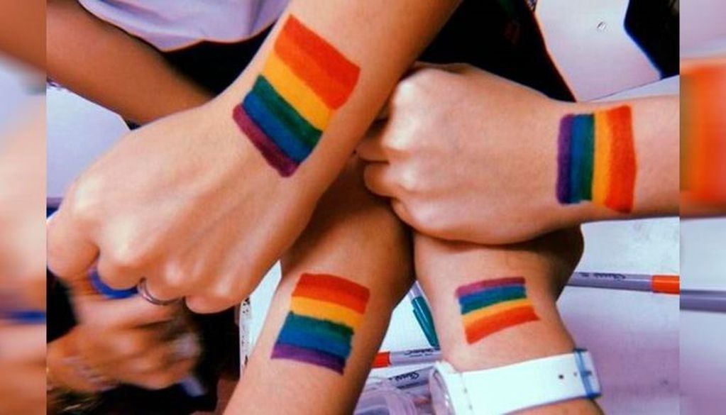 Jóvenes con banderas LGBT pintadas en sus manos (Web)