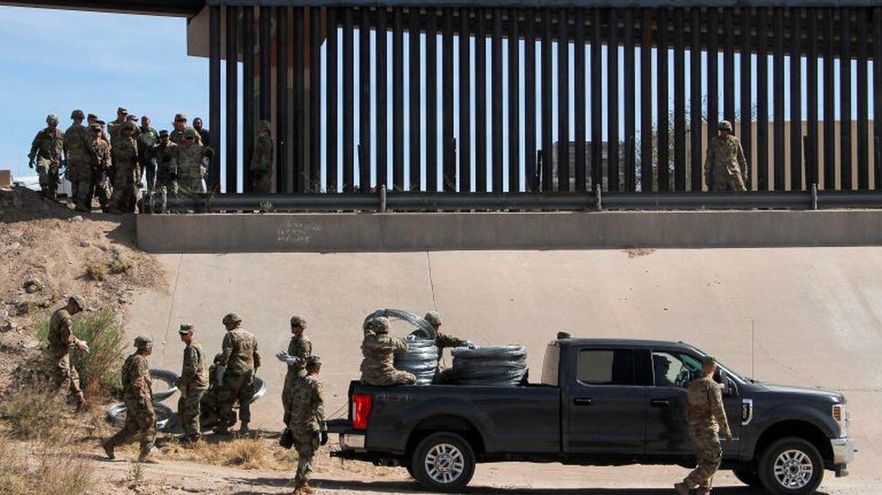 U.S. soldiers prepare to install barb wire by the US-Mexico border fence in El Paso, Texas state, US, as seen from Ciudad Juarez, Chihuahua state, Mexico on April 4, 2019. - US President Donald Trump is expected to visit a section of the border fence in Calexico during his tour to California on Friday. (Photo by Herika Martinez / AFP)