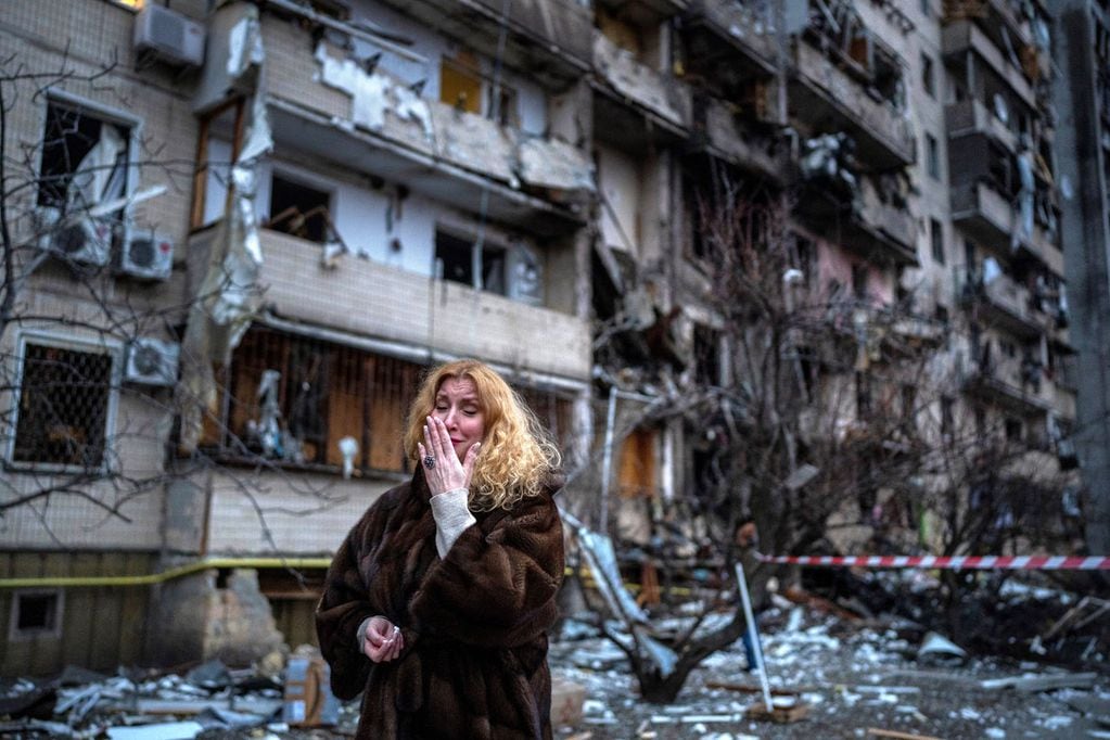 Natali Sevriukova llora junto a su casa tras un ataque con cohetes en la ciudad de Kiev, Ucrania, el viernes 25 de febrero de 2022. (AP)