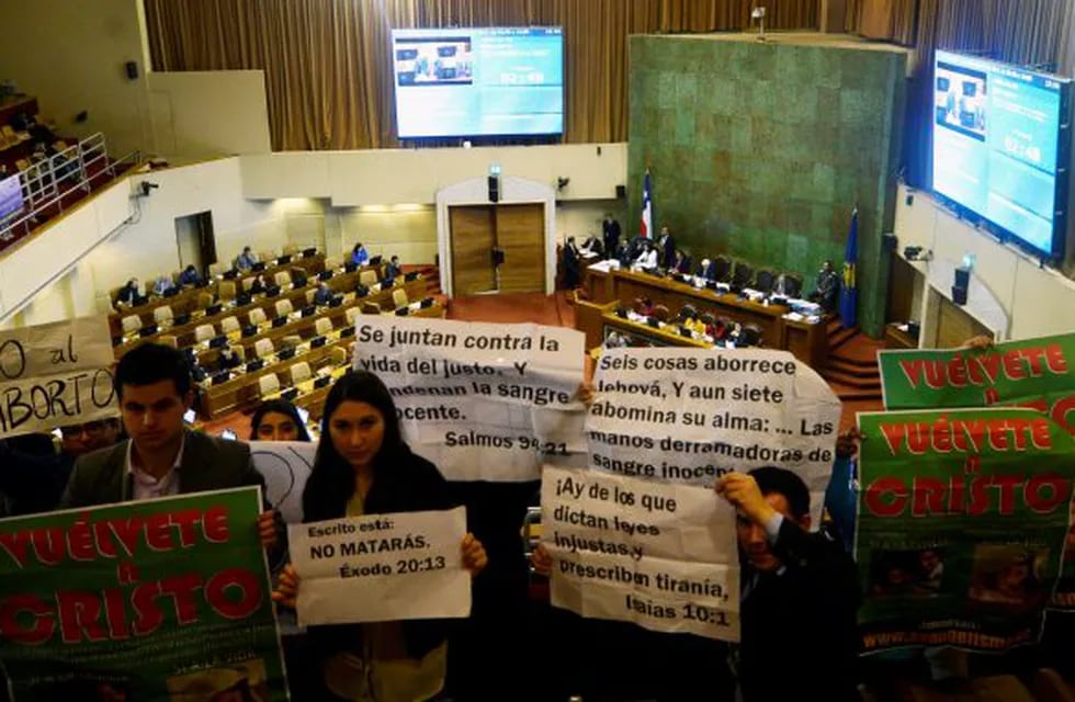 Manifestantes sostienen carteles en rechazo a la despenalización del aborto durante la sesión en la Camara de Diputados. (DPA)