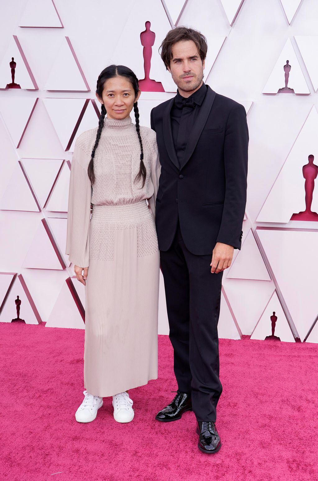 Chloe Zhao y Joshua James Richards en la alfombra roja.
