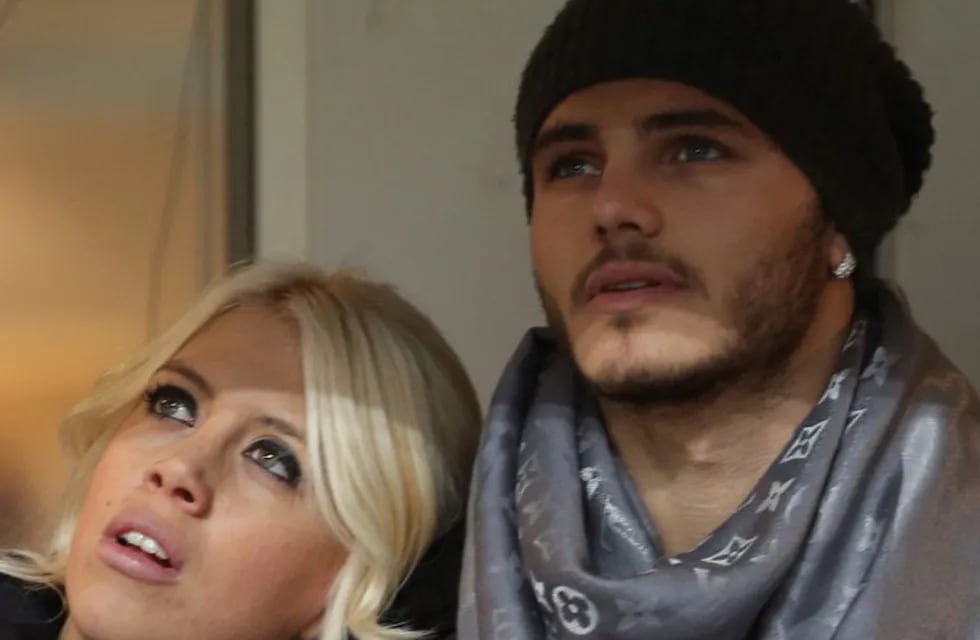 FILE - In this Jan. 13, 2014 file photo, Inter Milan forward Mauro Icardi, of Argentina, is flanked by his wife Wanda Nara as they sit in the stands prior to a Serie A soccer match between Inter Milan and Chievo, at the San Siro stadium in Milan, Italy, Monday, Jan.13, 2014. Two months ago, Mauro Icardi was one of Inter Milan's favored players, on Thursday, Feb. 14, 2019, he was training with just a handful of teammates at their training ground after a rapid fall from grace after Icardi and Inter have been in protracted talks over renewing his contract, which expires in 2021, with agent-wife Wanda Nara being particularly outspoken over the past month.  (AP Photo/Luca Bruno)