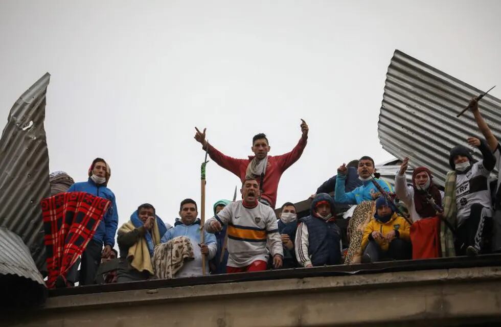 Rioting inmates protest from the roof of the Villa Devoto prison as they protest against authorities who they say are not doing enough to prevent the spread of coronavirus inside the jail in Buenos Aires, Argentina, Friday, April 24, 2020. (AP Photo/Natacha Pisarenko)