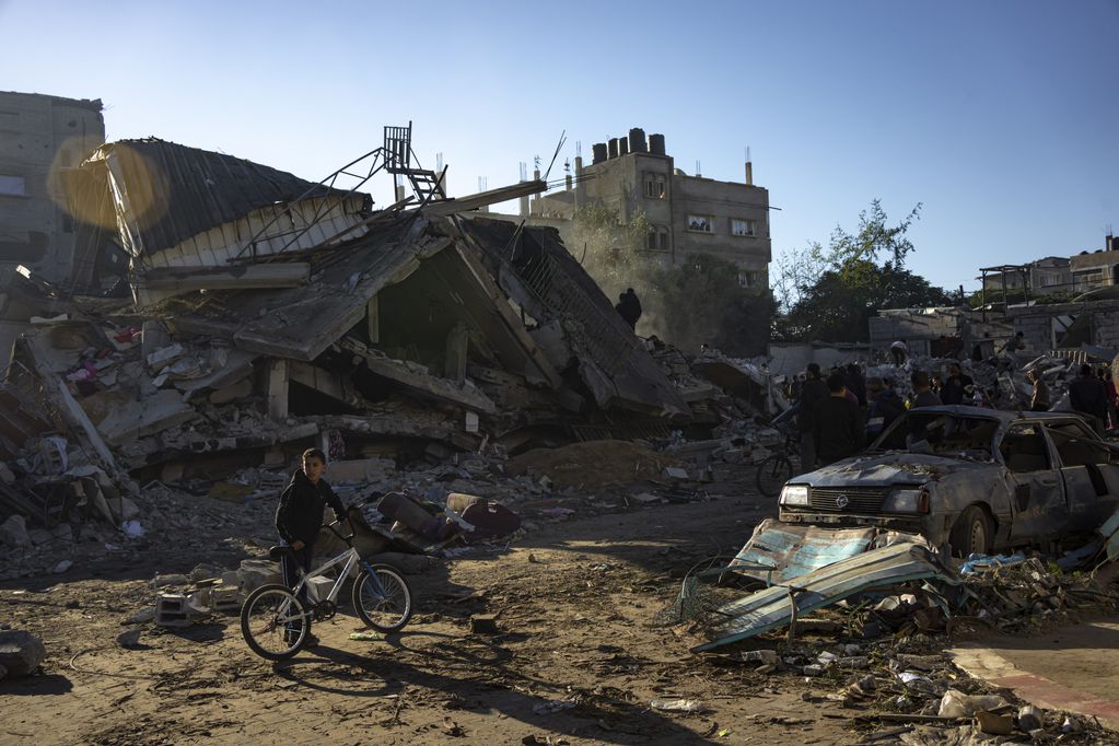 Palestinos buscan cadáveres y sobrevivientes entre los escombros de un edificio residencial destruido en un ataque aéreo de Israel, en Rafah, en el sur de la Franja de Gaza, el 15 de diciembre de 2023. 