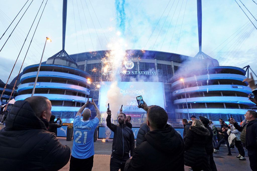 Los fanáticos del Manchester City celebran el título en las afueras de su estadio. (AP)
