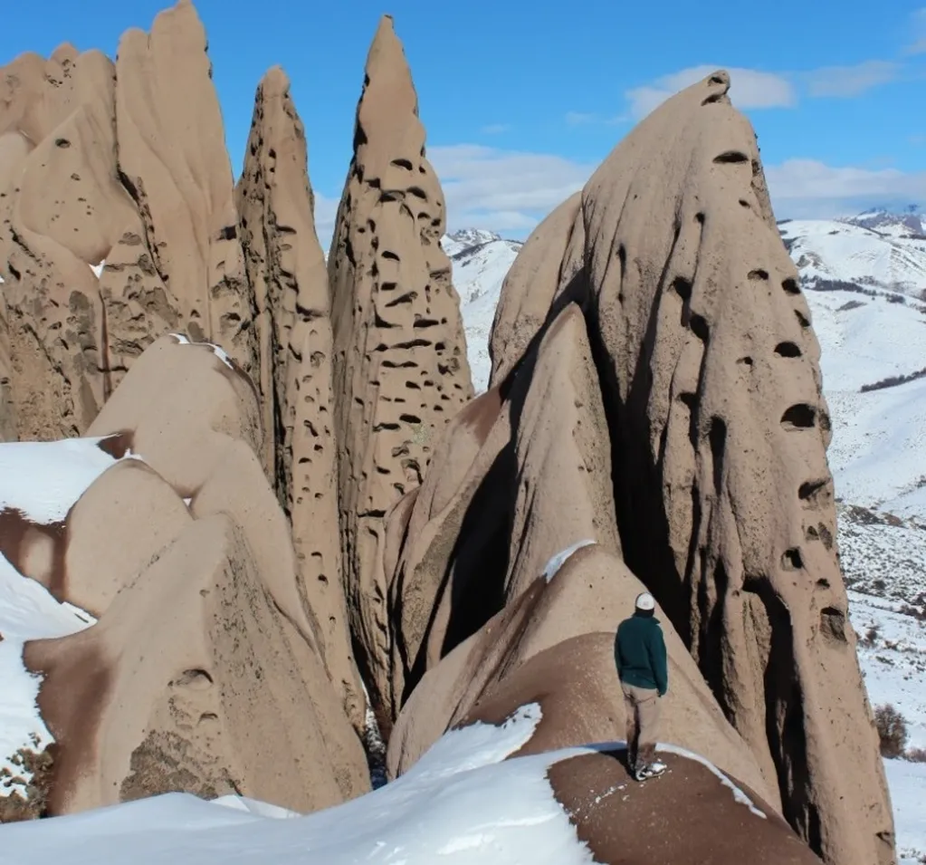 El Cerro La Buitrera ofrece un increíble paisaje con nieve que contrasta con el color de la colina.
