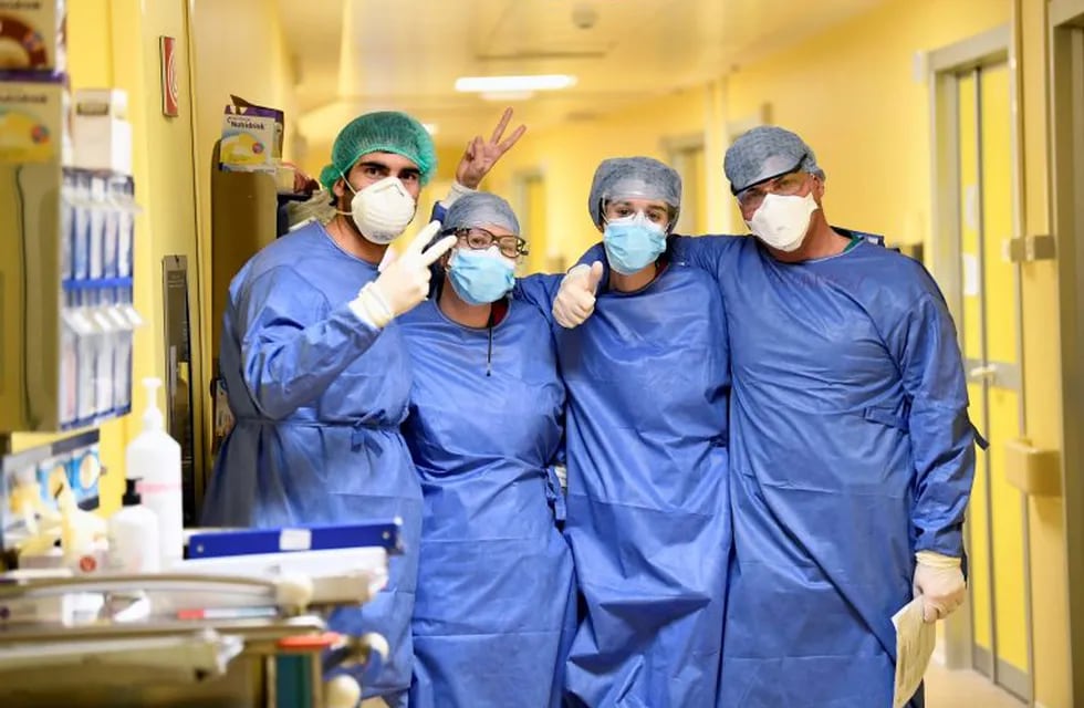Members of the medical staff in protective suits pose for a photo in the COVID-19 intensive care unit at the San Raffaele hospital in Milan, Italy, March 27, 2020. REUTERS/Flavio Lo Scalzo