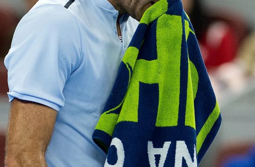 Juan Martin del Potro of Argentina wipes his face with a towel during his men's singles match against Grigor Dimitrov of Bulgaria at the China Open tennis tournament in Beijing on October 4, 2017. / AFP PHOTO / NICOLAS ASFOURI