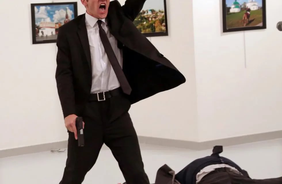 FILE - In this Monday, Dec. 19, 2016 file photo Mevlut Mert Altintas shouts after shooting Andrei Karlov, right, the Russian ambassador to Turkey, at an art gallery in Ankara, Turkey. Associated Press photographer Burhan Ozbilici won the 2017 World Press 